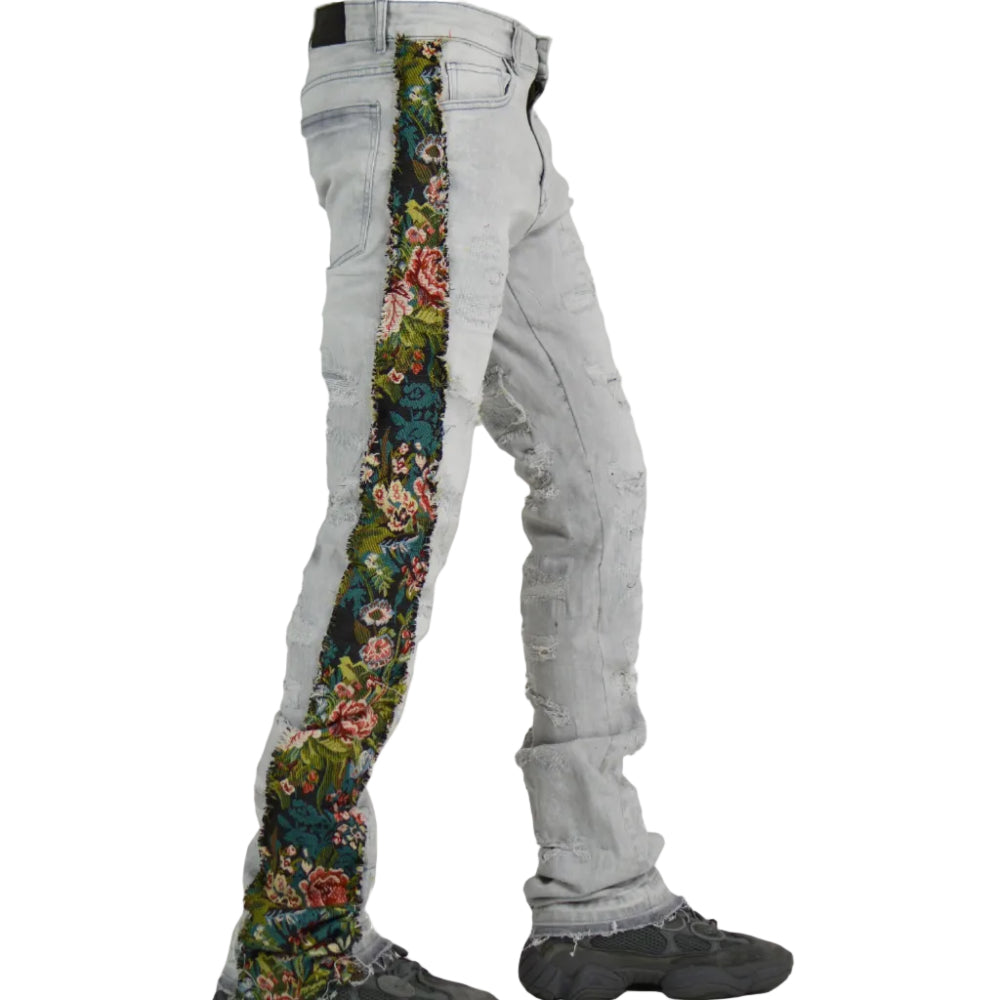Light gray jeans with floral pattern on one side, worn by a person.